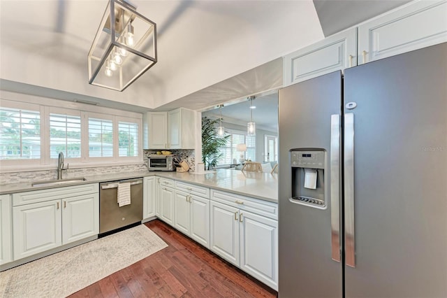 kitchen with stainless steel appliances, decorative light fixtures, dark wood-type flooring, white cabinets, and sink