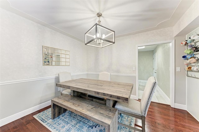 dining room with dark hardwood / wood-style floors and an inviting chandelier