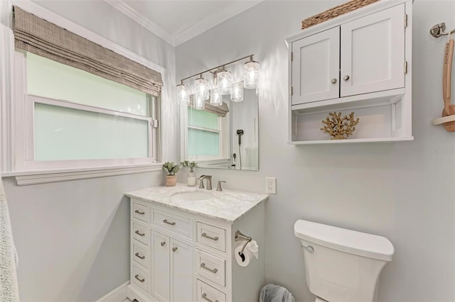 bathroom featuring toilet, ornamental molding, and vanity