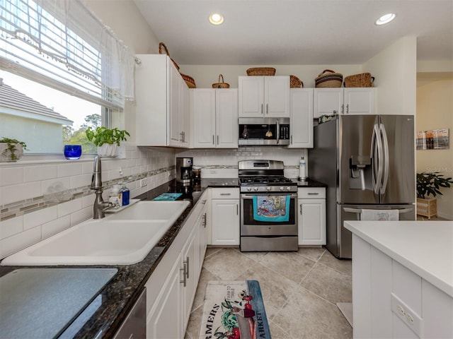 kitchen with sink, white cabinetry, backsplash, and appliances with stainless steel finishes