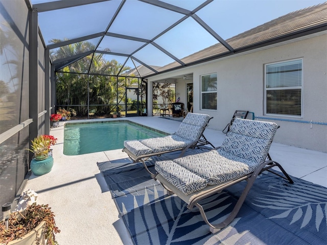 view of swimming pool featuring a patio area, ceiling fan, and a lanai