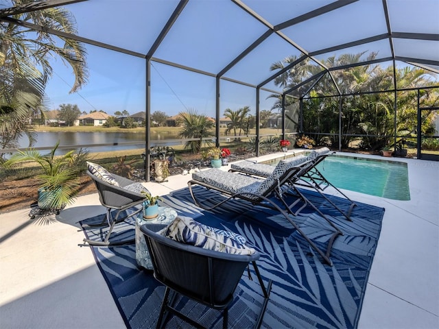 view of swimming pool with a patio area, glass enclosure, and a water view