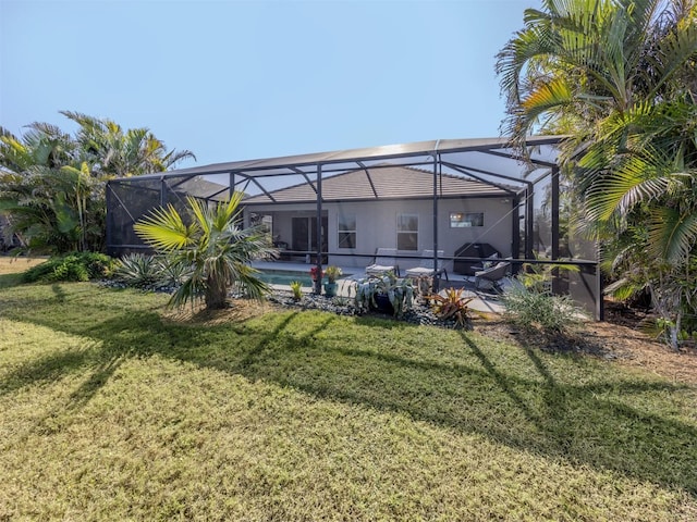 back of property featuring a lanai, a pool, a patio area, and a yard