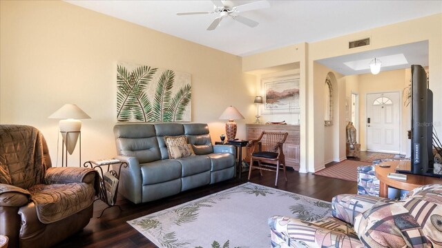 living room featuring ceiling fan and dark hardwood / wood-style flooring