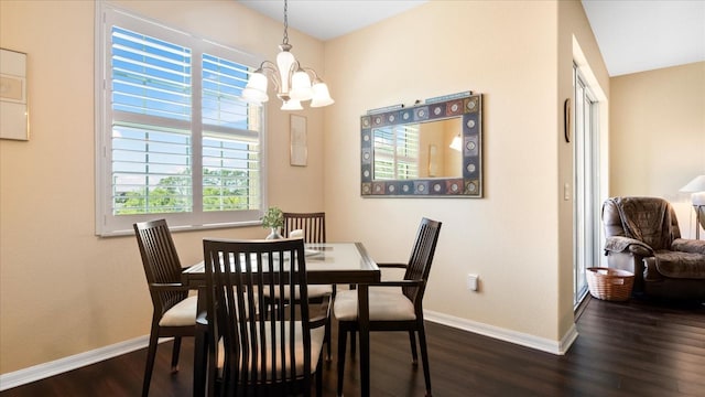 dining area featuring dark hardwood / wood-style floors and an inviting chandelier