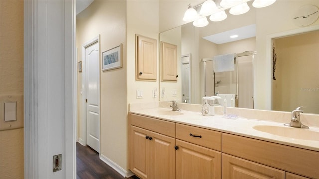 bathroom featuring hardwood / wood-style flooring, vanity, and walk in shower