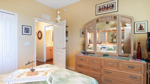 bedroom featuring hardwood / wood-style floors and ensuite bath