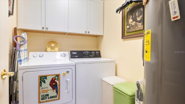 clothes washing area featuring cabinets, independent washer and dryer, and water heater