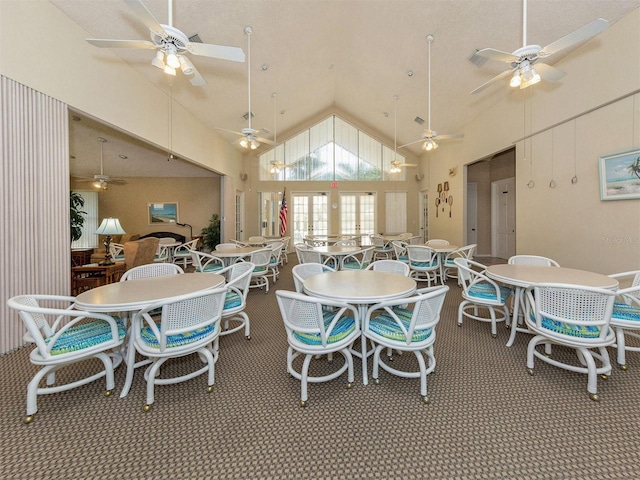 dining room featuring high vaulted ceiling and carpet