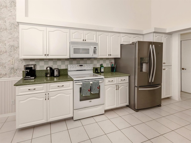 kitchen with white cabinetry, white appliances, and light tile patterned flooring