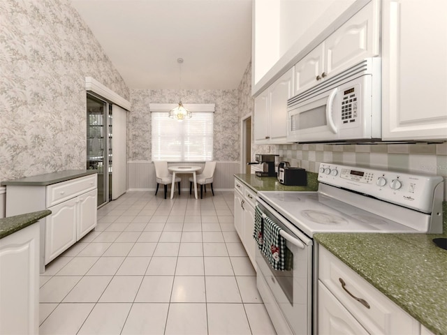 kitchen with decorative light fixtures, white cabinetry, a chandelier, light tile patterned floors, and white appliances