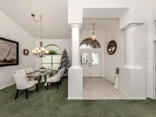 carpeted foyer entrance with french doors, high vaulted ceiling, decorative columns, and a notable chandelier