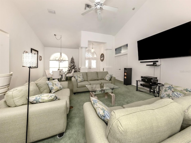 living room featuring carpet flooring, ceiling fan with notable chandelier, and high vaulted ceiling