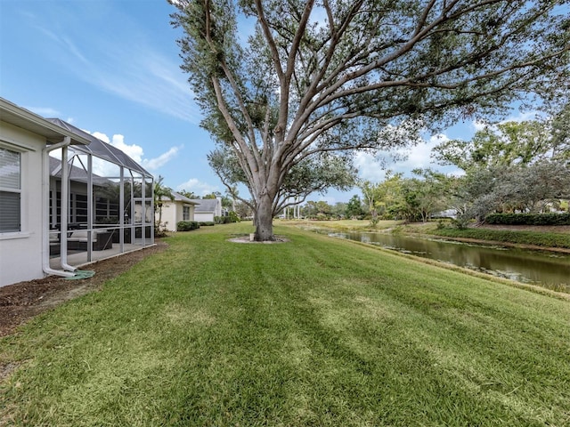 view of yard with a water view and glass enclosure