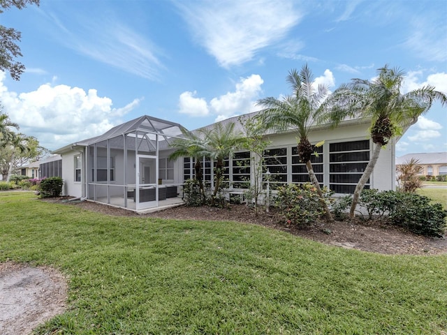 back of property featuring a yard and glass enclosure