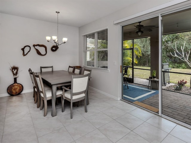 tiled dining room featuring ceiling fan with notable chandelier and a wealth of natural light