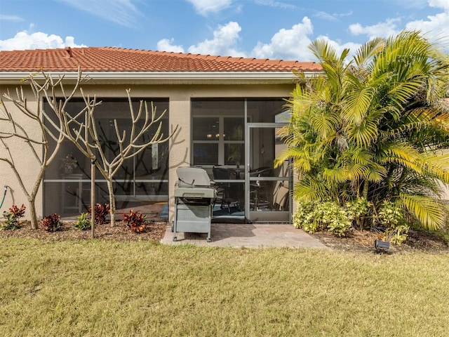 back of house with a lawn and a sunroom