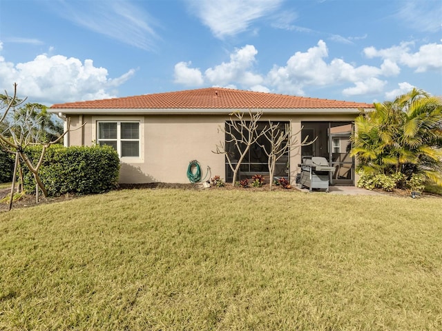 rear view of property featuring a yard and a sunroom