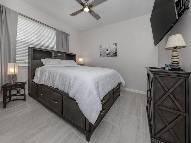 bedroom with ceiling fan, baseboards, and wood tiled floor