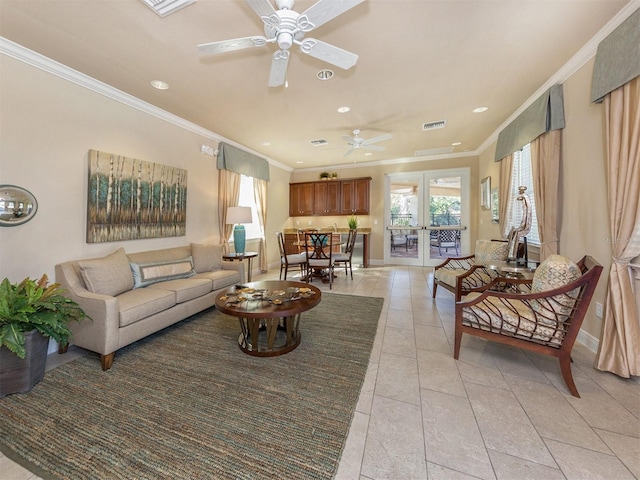 living room featuring ceiling fan, visible vents, ornamental molding, and plenty of natural light