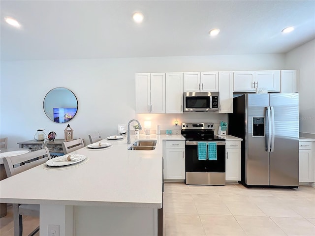 kitchen with kitchen peninsula, sink, white cabinets, and stainless steel appliances