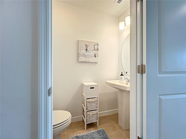 bathroom with toilet and tile patterned floors