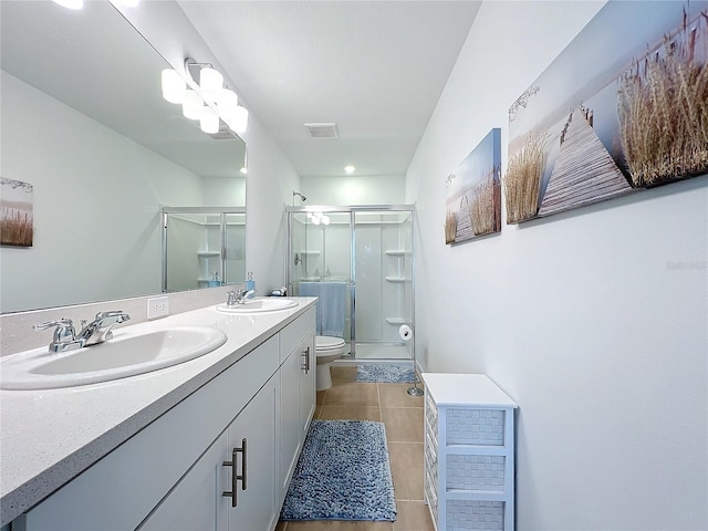 bathroom featuring tile patterned flooring, vanity, an enclosed shower, and toilet