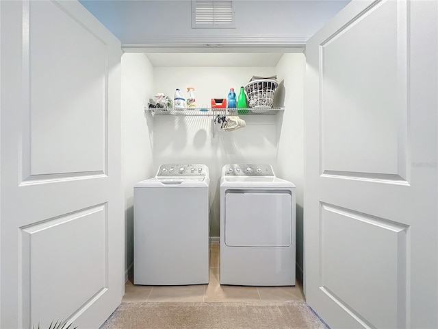 laundry room featuring independent washer and dryer and light tile patterned floors