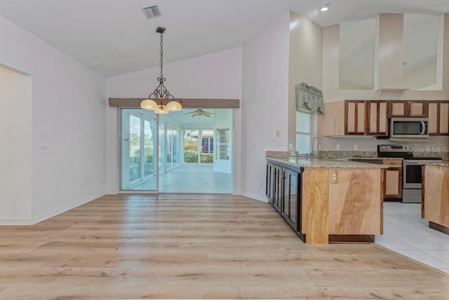 kitchen with hanging light fixtures, light wood-type flooring, appliances with stainless steel finishes, kitchen peninsula, and ceiling fan with notable chandelier