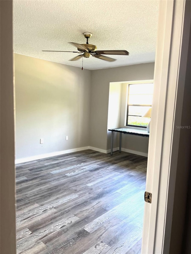 spare room featuring hardwood / wood-style flooring, ceiling fan, and a textured ceiling