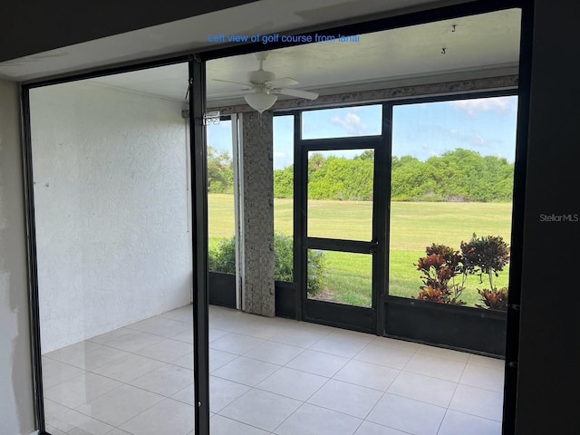 unfurnished sunroom featuring ceiling fan