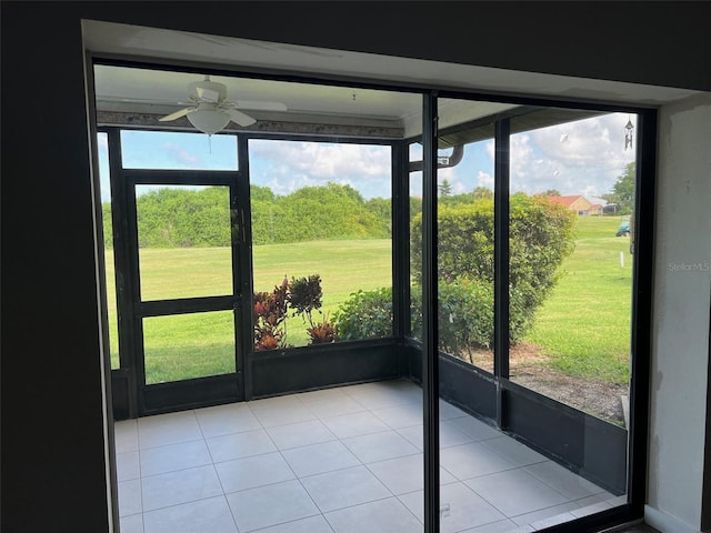 unfurnished sunroom featuring ceiling fan