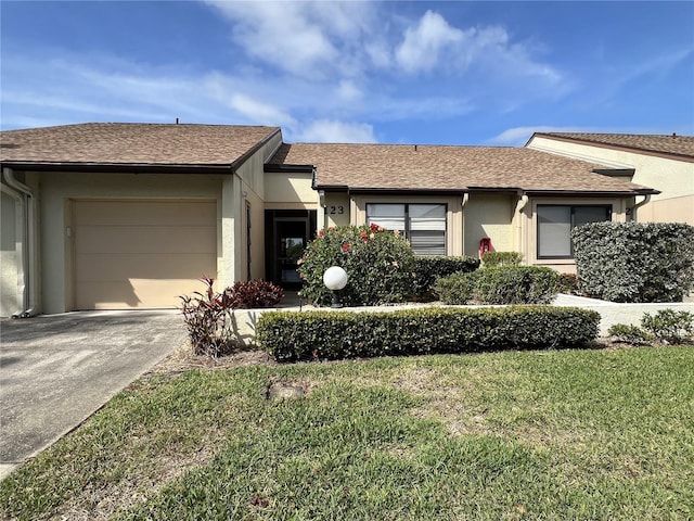 single story home featuring an attached garage, a shingled roof, driveway, stucco siding, and a front lawn