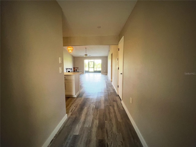 hallway featuring dark wood-style floors and baseboards