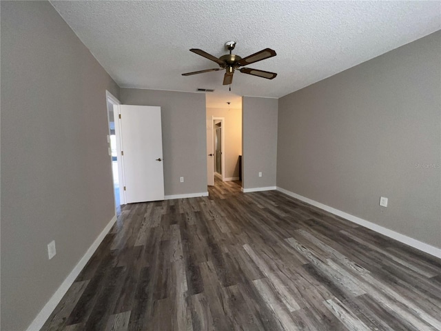 unfurnished bedroom featuring a textured ceiling, dark wood finished floors, visible vents, and baseboards