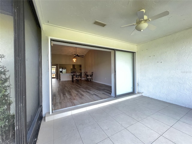 unfurnished sunroom with ceiling fan and visible vents