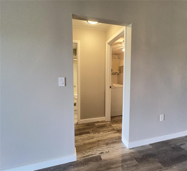 corridor featuring baseboards and wood finished floors