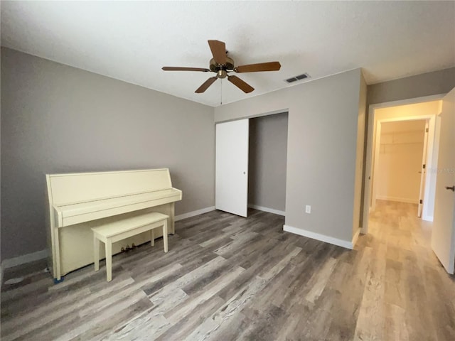 unfurnished bedroom featuring baseboards, a closet, visible vents, and wood finished floors