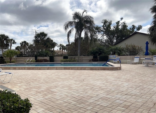 pool featuring a patio area and fence