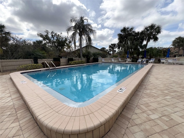 pool with fence and a patio