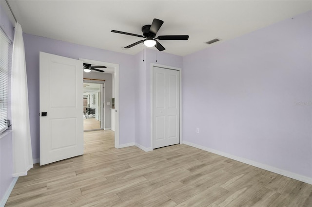 unfurnished bedroom with ceiling fan, light hardwood / wood-style floors, and a closet