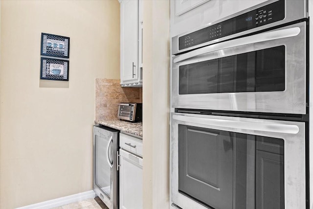 kitchen featuring white cabinetry, light stone countertops, beverage cooler, tasteful backsplash, and double oven