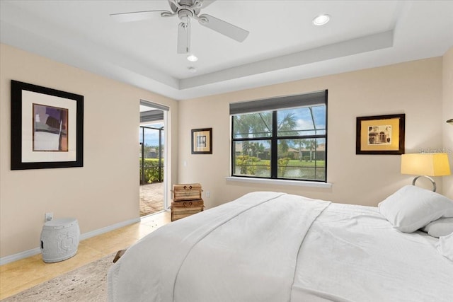 bedroom featuring a raised ceiling, access to exterior, ceiling fan, and light tile patterned floors