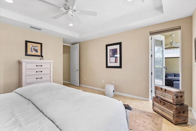 tiled bedroom featuring a tray ceiling and ceiling fan