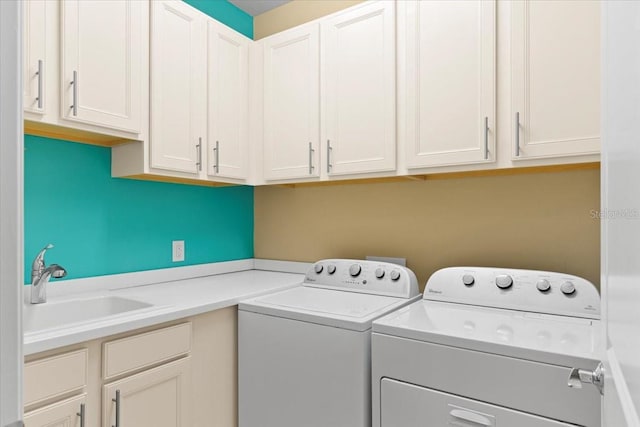 washroom featuring cabinets, independent washer and dryer, and sink