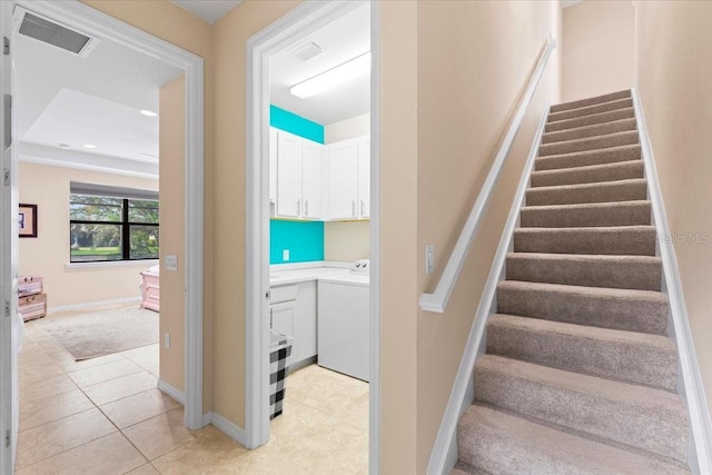 stairs featuring tile patterned flooring and washer / dryer