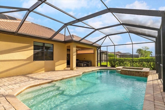 view of pool featuring an in ground hot tub, glass enclosure, and a patio area