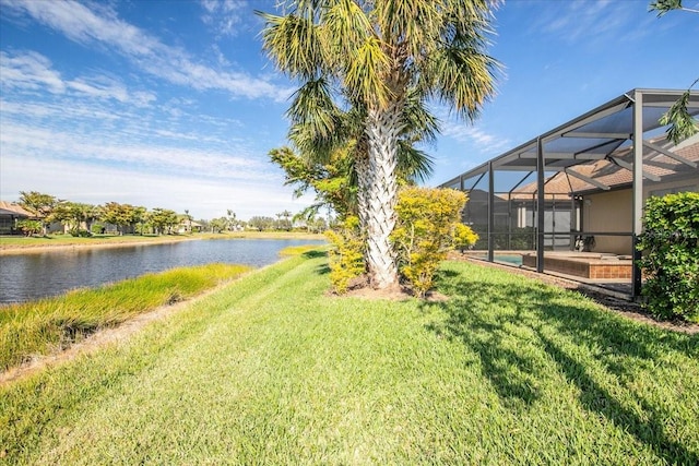 view of yard with a water view, glass enclosure, and a swimming pool