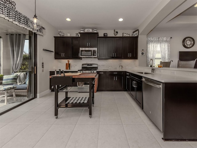 kitchen featuring sink, pendant lighting, stainless steel appliances, and a wealth of natural light