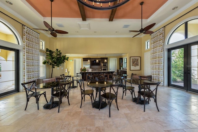 dining area with ceiling fan, beam ceiling, french doors, and a raised ceiling